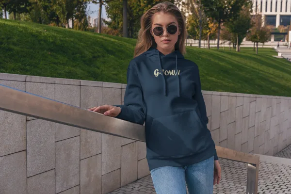 Model draagt de G-TOWN Champagne Chique Dames Hoodie – stijlvolle en duurzame streetwear hoodie in het navy met champagnekleur oppdruk